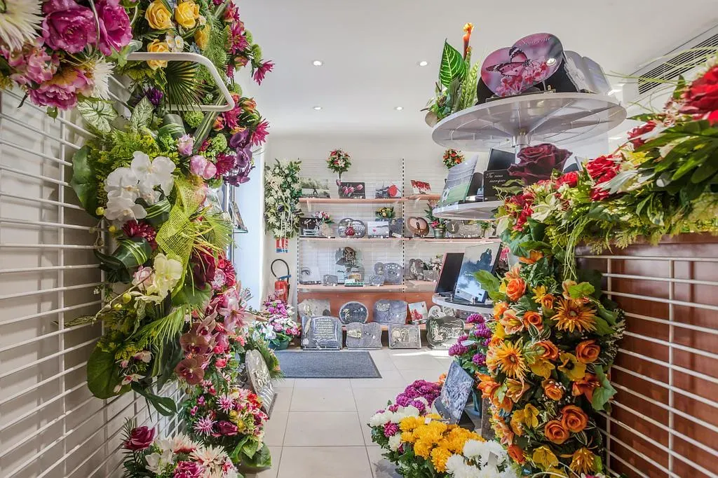 Vase de fleurs et petites bougies posés sur une pierre tombale en granit rénovée
